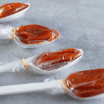 Close-up shot of plastic spoons each filled with soft, tangy tamarind candy wrapped in cellophane. These individually portioned spoons capture the sweet-and-sour flavor prized in many Mexican candies