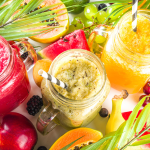 A variety of vibrant tropical smoothies in mason jars, surrounded by exotic fruits like watermelon, papaya, and kiwi for a nutritious, summery treat.